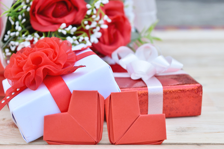 Red roses bouquet, gift box and red hearts shape on wooden background. Concept for Valentine's Day, Birthday or Wedding.の写真素材