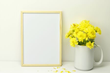 Frame mockup with yellow flowers in vase on white background.の写真素材