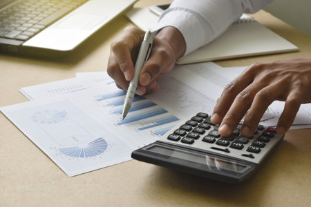 businessman working analyzing financial graphs and charts report on desk in office. accounting and...