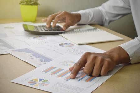 businessman working analyzing financial graphs and charts report on desk in office. accounting and financial business concept.の写真素材