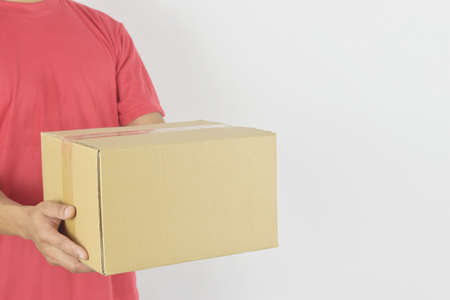 Delivery concept. Delivery man holding parcel box for customer services on white background.の写真素材