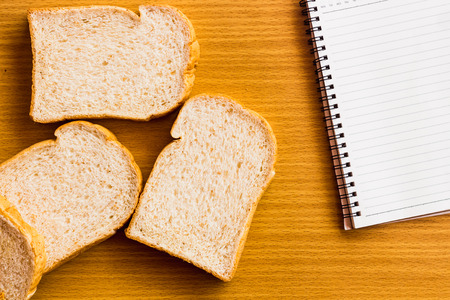 peanut butter and breakfast on wood table with note book and spaceの写真素材