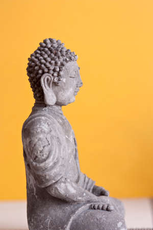 stone sitting buddha  yellow backgroundの写真素材
