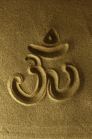 Om symbol hand drawn in the sandの写真素材