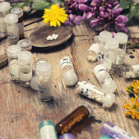 bottles with homeopathy globules and spoon, decorated with flower yellowのeditorial素材