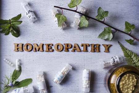 Table with written text Homeopathy, homeopathy globules and bottlesのeditorial素材