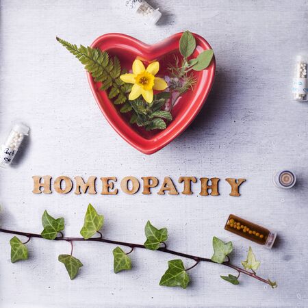 Table with written text Homeopathy, homeopathy globules and bottlesのeditorial素材