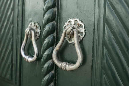 two small metal knocker in wooden doorの写真素材