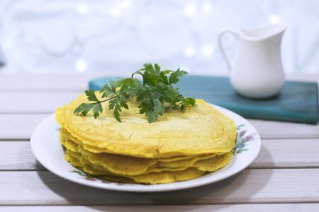 Salty pancakes with turmeric and parsley. Christmas background. Wooden background