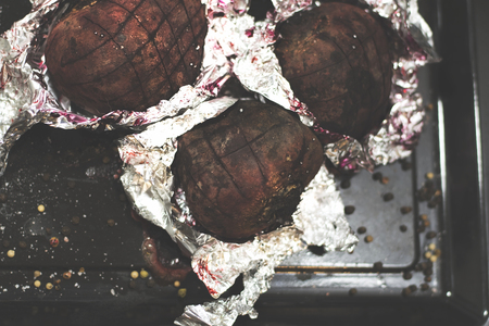 Baking with aluminium foil. Baked beets for a Christmas soup. Holiday food. Top view beetsの写真素材