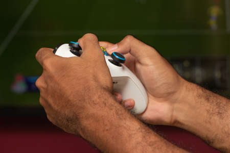 man holding on a xbox gamepad in front of game screenのeditorial素材