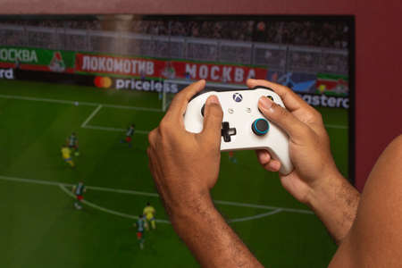 man holding on a xbox gamepad in front of game screenのeditorial素材