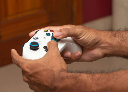 man holding on a xbox gamepad in front of game screenのeditorial素材