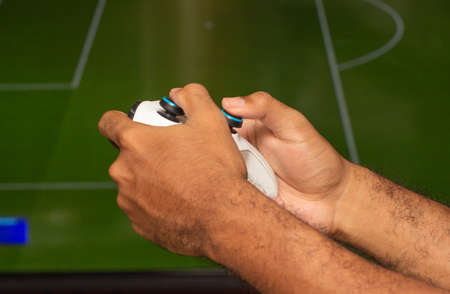 man holding on a xbox gamepad in front of game screenのeditorial素材