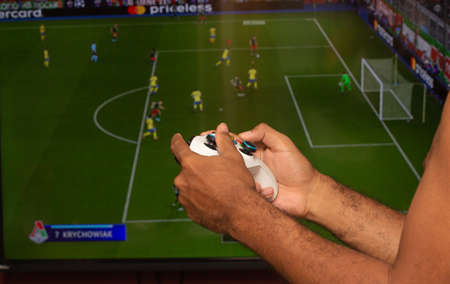 man holding on a xbox gamepad in front of game screenのeditorial素材