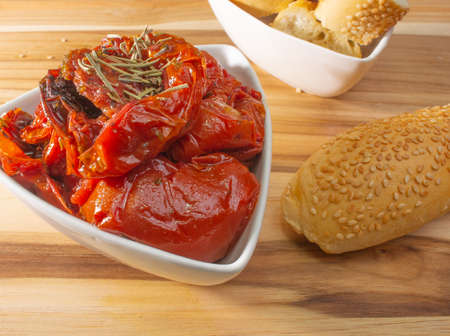 Bowl Full Of Dryied Tomato A Surrounding By Bread Covered With Sesameの写真素材