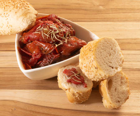 Bowl Full Of Dryied Tomato A Surrounding By Bread Covered With Sesameの写真素材