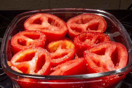 top view of fresh red tomatoes with salt under the stoveの写真素材