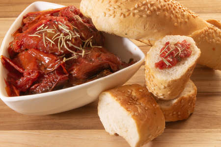 Bowl Full Of Dryied Tomato A Surrounding By Bread Covered With Sesameの写真素材