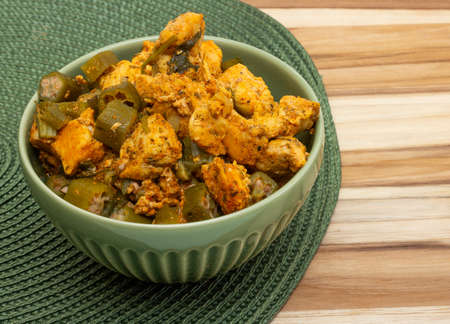 top view brazilian meal with bowl full of piece of chicken and okra on the wood backgroundの写真素材