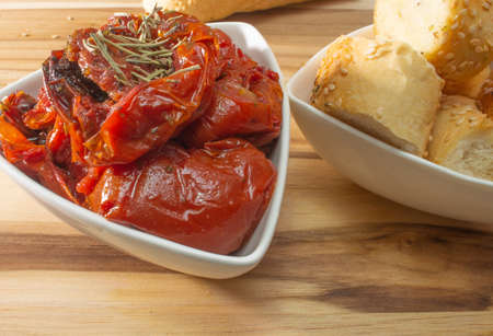 Bowl Full Of Dryied Tomato A Surrounding By Bread Covered With Sesameの写真素材