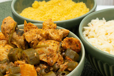 delicious brazilian meal in three bowls full of piece of chicken, rice and flourの写真素材
