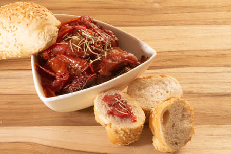 Bowl Full Of Dryied Tomato A Surrounding By Bread Covered With Sesameの写真素材
