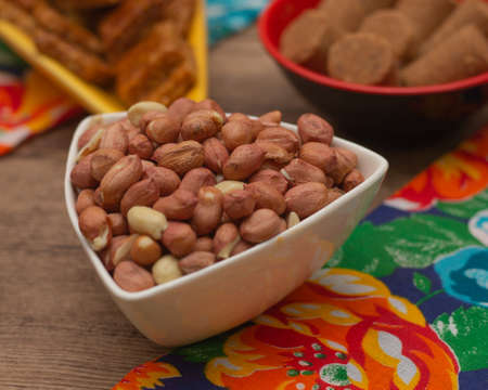 several bowls full of dried and sweet peanuts on the table