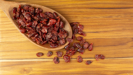 spoon full of dried fruits on the wood tableの写真素材