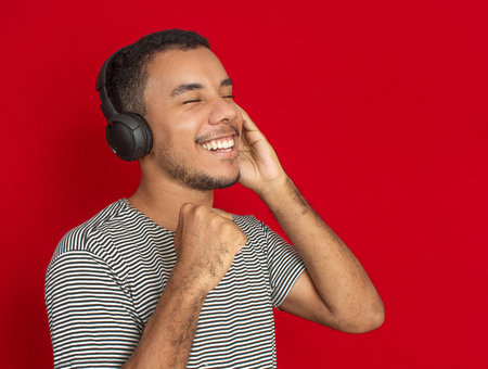 a man using a cellphone with a red backgroundの写真素材
