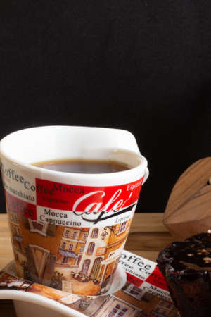 a cup of coffee under the wood table with a black backgroundの写真素材