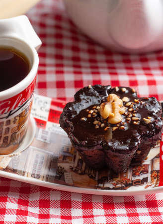 a cup of coffee and a chocolate candie under the wood tableの写真素材