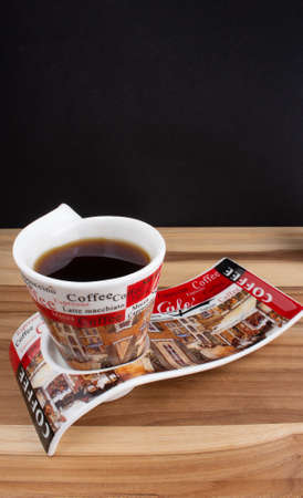 a cup of coffee under the wood table with a black backgroundの写真素材
