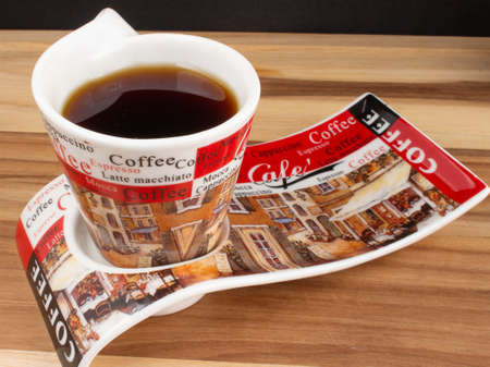 a cup of coffee under the wood table with a black backgroundの写真素材