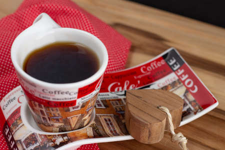 a cup of coffee under the wood table with a black backgroundの写真素材