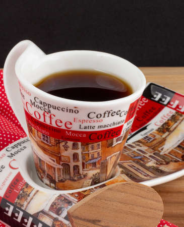 a cup of coffee under the wood table with a black backgroundの写真素材