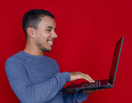 man smiling listening and holding on a laptopの写真素材