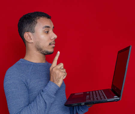 man smiling listening and holding on a laptopの写真素材