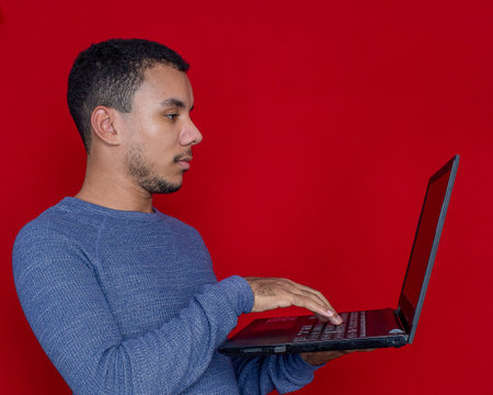 man smiling listening and holding on a laptopの写真素材