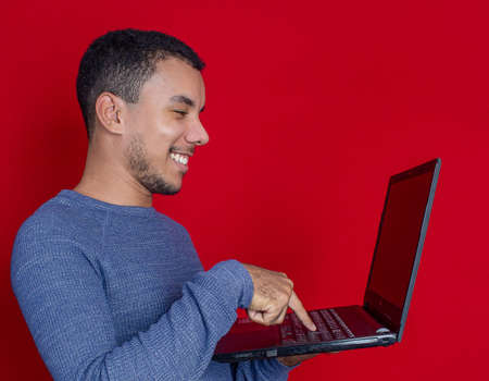 man smiling listening and holding on a laptopの写真素材