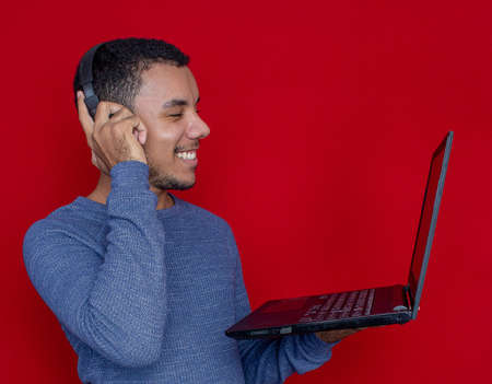 man smiling listening and holding on a laptop andの写真素材