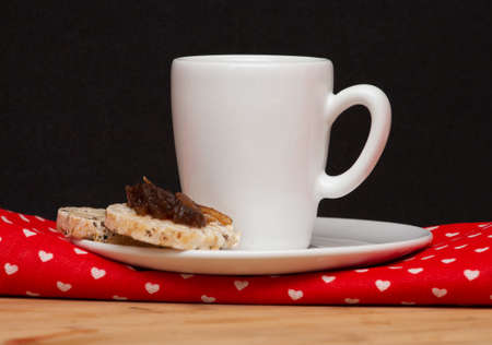 a cup of coffee and a rice vegan cookies with a jelly on the topの写真素材