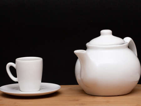 cup of coffee and a coffee pot under the wood tableの写真素材