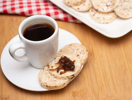 cup of coffee beside rice cookies under the wood tableの写真素材