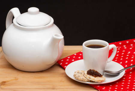 a coffe pot surrouded by a cup of coffee beside rice vegan cookies jelly on the topの写真素材