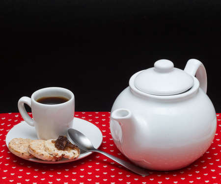a cup of coffee beside a rice vegan cookies surounded by a coffee potの写真素材