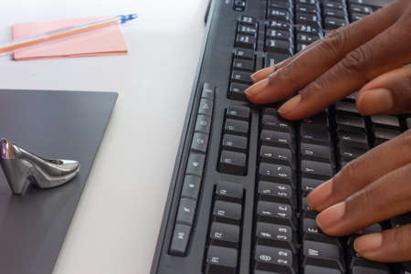 person typing on keyboard in front of a tabletの写真素材