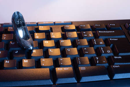 A keyboard with a small female heel shoe on topの写真素材