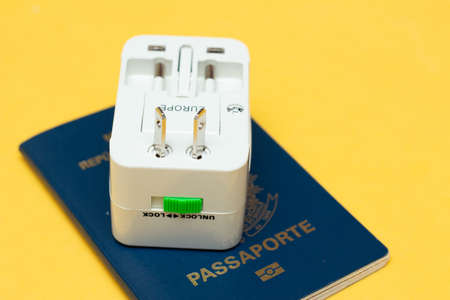 universal socket adapter over a passport with colored backgroundの写真素材