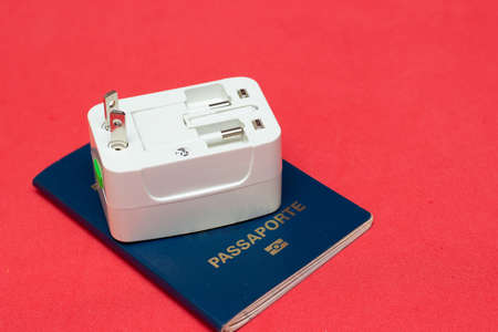 universal socket adapter over a passport with colored backgroundの写真素材